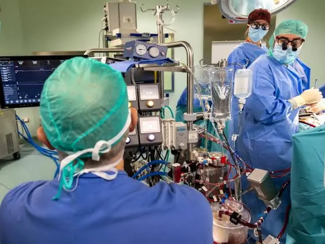 Surgical team performing cardiac surgery with perfusionist managing the CPB machine.